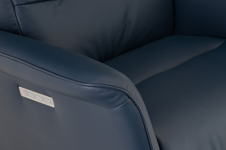 Close-up of a dark blue leather chair with a visible brand label.
